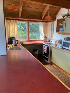 a kitchen with a red counter top in a room at Beach side Waikanae Bach in Waikanae