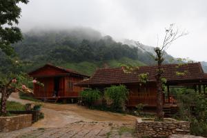 a house on a dirt road in front of a mountain at ANOR Farmstay - Two Double Bed in Hue