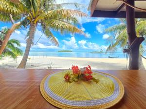 a hat on a table with a view of the beach at Tikehau Herearii in Tikehau Airport
