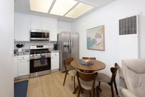 a kitchen with a table and a stainless steel refrigerator at Luxury At Pier Avenue in Oceano