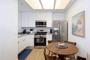a kitchen with white cabinets and a table with a cake on it at Luxury At Pier Avenue in Oceano