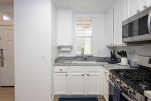 a white kitchen with a sink and a stove at Luxury At Pier Avenue in Oceano +8 photos