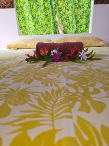 a bed with flowers laying on top of it at Tikehau Herearii in Tikehau Airport