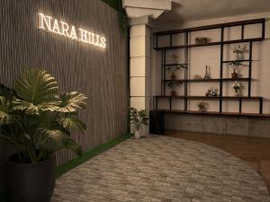 a lobby with plants and a sign that readsarma hits at Nara Hills in Sembalun Lawang