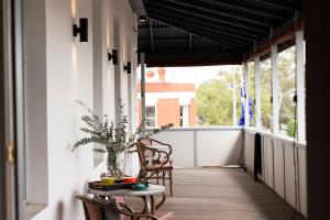 a balcony with two chairs and a table with a plant at The Corner Hotel Alexandra in Alexandra