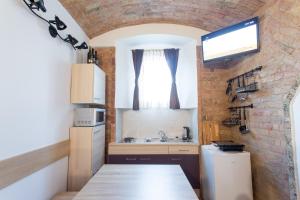 cocina pequeña con fregadero y pared de ladrillo en Guesthouse BED 4 YOU en Zagreb