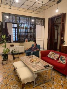 a man sitting on a couch in a living room at Casa Boedo in Buenos Aires