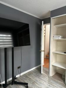 a room with a wall with a tv and a closet at Casa full in Santiago