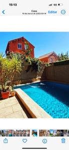 a picture of a swimming pool in front of a house at Casa full in Santiago