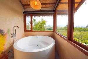 a bath tub in a bathroom with a window at Baannok at Motakhian in Pak Chong