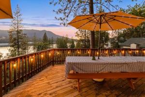 a table with an umbrella on a deck with lights at Bass Lake Lodge in Bass Lake