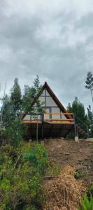 a house on top of a hill with trees at Glamping Jadiva in Cucunubá