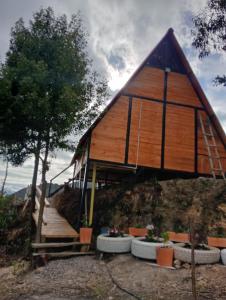 a house with a thatched roof on top of a hill at Glamping Jadiva in Cucunubá
