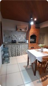 a kitchen with a table and a brick fireplace at Canto dos pássaros in Volta Redonda