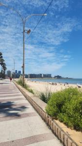 a beach with a street light and people on the beach at Monoambiente como en casa in Montevideo