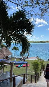 ein Strand mit Menschen, die auf dem Gras liegen, und Wasser in der Unterkunft Posada la Bendición in Xul-Ha