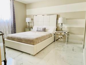 a white bedroom with a large bed and two lamps at Ocean & Bay Views 2BR 2BA Beach Condo! Parking in Miami Beach +52 photos