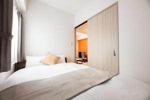 a bedroom with a large white bed and a mirror at SPAZIO 4 Tenjin Minami in Fukuoka +31 photos