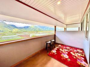 a room with a large window and a red rug at Nara Hills in Sembalun Lawang