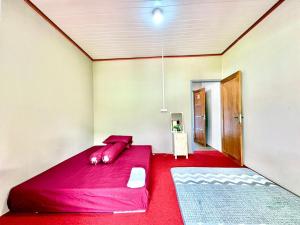 a bedroom with a large red bed in a room at Nara Hills in Sembalun Lawang