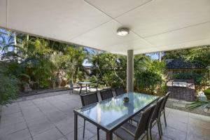 a glass table and chairs on a patio at Applecross - Perfect For A Weekend Escape in North Avoca