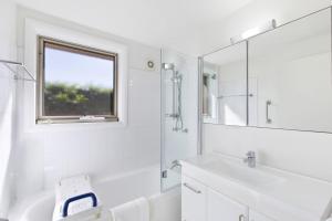 a white bathroom with a sink and a mirror at Applecross - Perfect For A Weekend Escape in North Avoca +2 photos