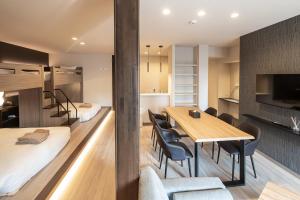 a room with a bed and a table and chairs at ReLA Kashiwa Eki Nishi in Kashiwa