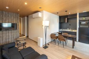a living room and kitchen with a couch and a table at ReLA Kashiwa Eki Nishi in Kashiwa