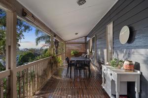 a balcony with a table and chairs on it at Flannel Flower Beach House in Shoal Bay