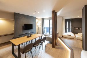 a living room with a table and chairs and a bedroom at ReLA Kashiwa Eki Nishi in Kashiwa