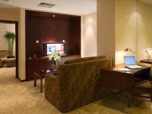 a living room with a couch and a laptop on a table at Wanshang Garden Hotel in Beijing