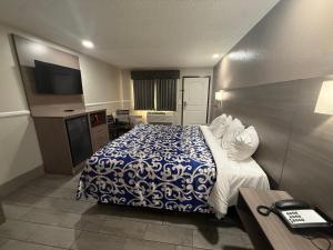 a hotel room with a bed with a blue and white blanket at SimpleStay Suites - Downtown San Bernardino in San Bernardino