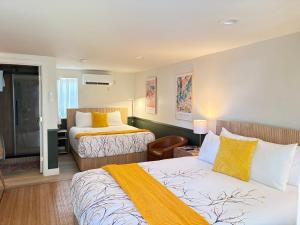 a hotel room with two beds with yellow sheets at Riverwalk Park Inn in Chelan