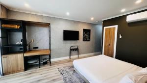 a bedroom with a bed and a desk and a television at Park Inn by Radisson Melbourne Carlton in Melbourne