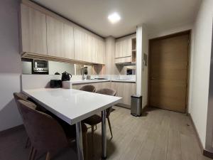 a kitchen with a white table and some chairs at Lagos centro Temuco in Temuco