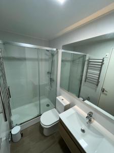 a bathroom with a toilet and a shower and a sink at Lagos centro Temuco in Temuco