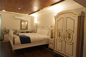 a bedroom with a white bed and a wooden ceiling at State Beach Resort And Spa in Kannur +64 photos