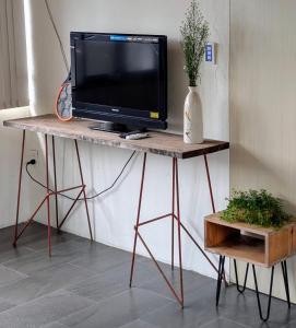 a tv sitting on a wooden table with a television at roc rach homestay in Ấp Tân Hà
