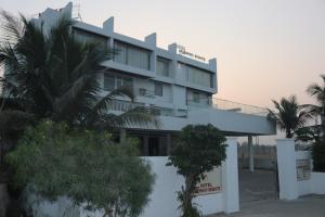 a white building with trees in front of it at Hotel Vaishnavi Heights in Aurangābād