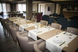 a row of tables and chairs with wine glasses on them at Hotel Palazzo in Gornji Vakuf