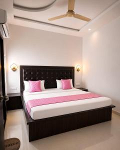 a bedroom with a large bed with pink pillows at La Buddha Villagers Homestay - Near Taj Mahal Agra in Agra
