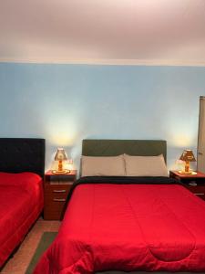 a bedroom with a red bed and two lamps on tables at Duna Blanca II in Fiambalá +4 photos