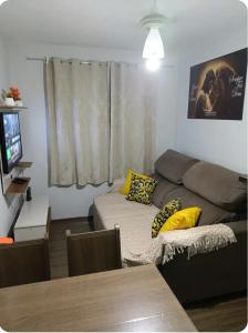 a living room with a couch and a bed at Apto Térreo Próximo HU e Aeroporto Vaga e Ar in Londrina