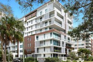 a tall white building with trees in front of it at Picnic Point Panoramic Views in Maroochydore