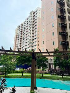 a large building with a tennis court in front of it at Rochester Garden Condo in Manila