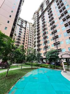 a swimming pool in front of a large building at Rochester Garden Condo in Manila