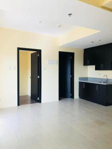 an empty room with black cabinets and a tile floor at Rochester Garden Condo in Manila +3 photos