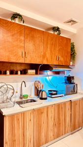 a kitchen with wooden cabinets and a stove top oven at Kozzy Loft Sitari Condominium in Bacolod