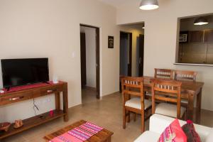 een woonkamer met een eettafel en een televisie bij Las Tulmas Apartamentos Salta in Salta