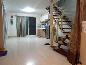a living room with a staircase and a kitchen at Casa Nicola BKK in Ban Na Song